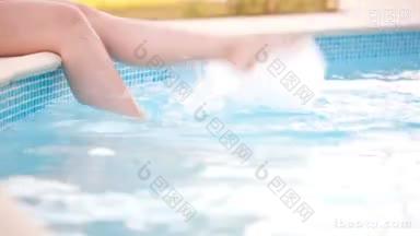 多<strong>莉</strong>拍摄的年轻女子在游泳池里玩水溅她的脚